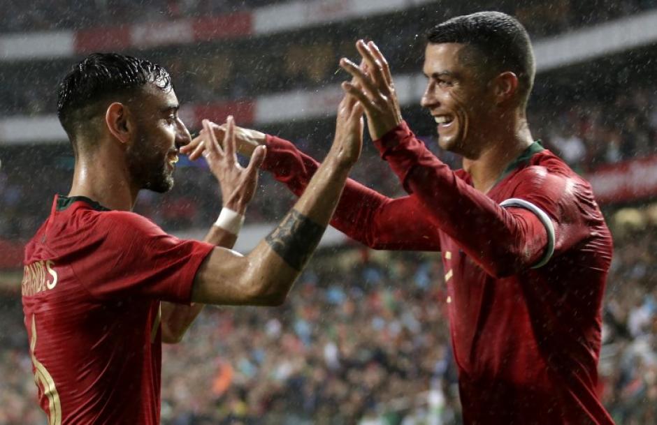 Cristiano Ronaldo festeja con Bruno Fernandes la segunda anotación de Portugal. (Foto: AFP)