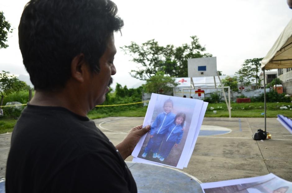 Elder de Jesús mira la foto de dos de sus hijos fallecidos en la tragedia, (Foto: Lucy Galindo/Soy502)