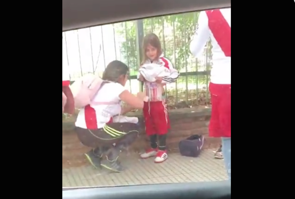 Aficionada de River le coloca bengalas a una niña para ingresar al Monumental. (Foto: Captura de video)