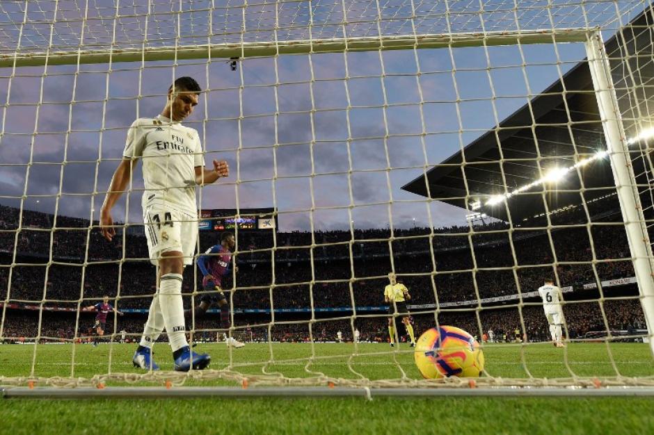 Casemiro va a traer la pelota a su portería, mientras el Barcelona festeja. (Foto: AFP)