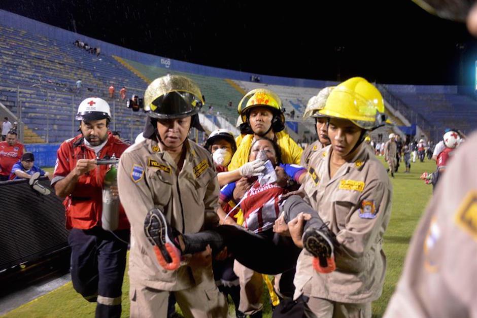 Una mujer es atendida por los bomberos en medio de los disturbios en un estadio de Honduras. (Foto: ElDiario)