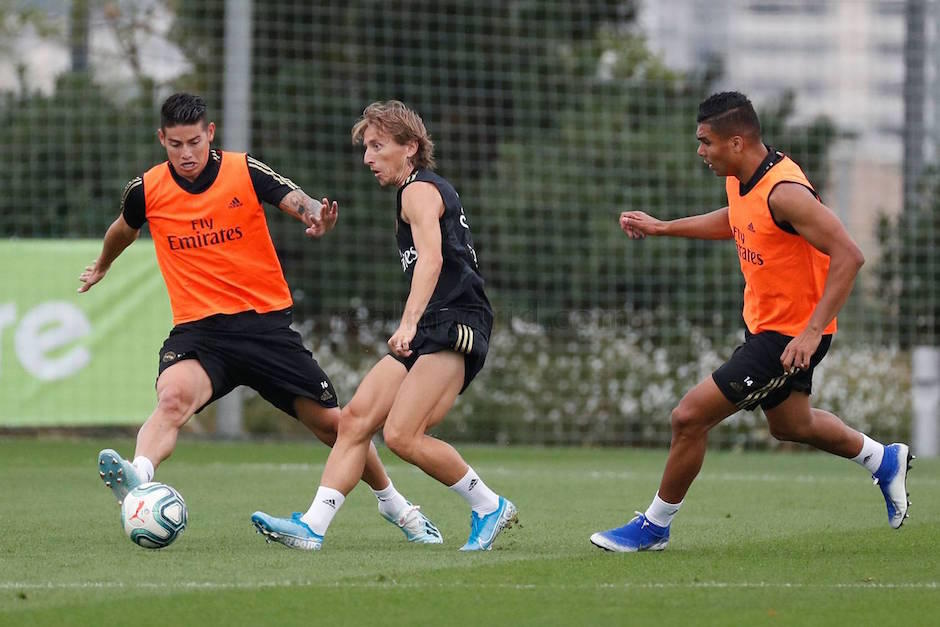 James Rodríguez intenta robarle el balón a Luka Modric durante el entrenamiento del miércoles. (Foto: Real Madrid)