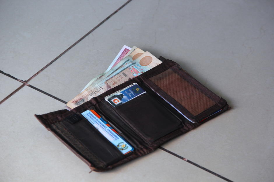 La billetera se encontraba tirada cerca de un centro comercial de la zona 6 y un buen ciudadano se la entregó al propietario de los documentos y el dinero extraviado. (Foto: Fredy Hernández/Soy502)