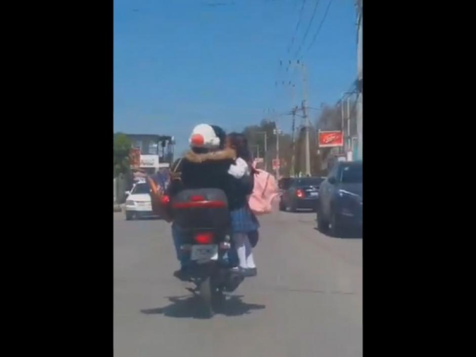 Un hombre fue captado en video cuando llevaba a su hija parada sobre el escape de una motocicleta. (Foto: Captura de pantalla)