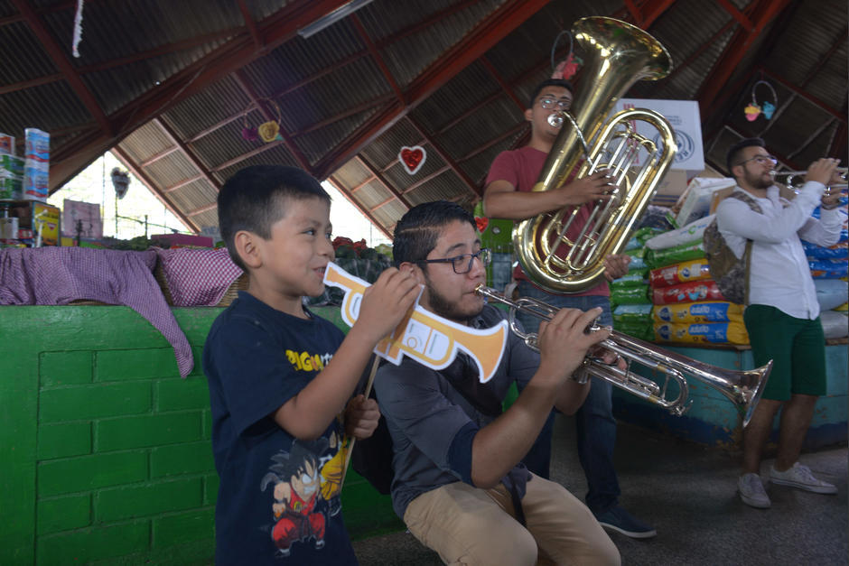 Un niño se une a uno de los músicos para disfrutar del recital. (Foto: Jesús Alfonso/Soy502)