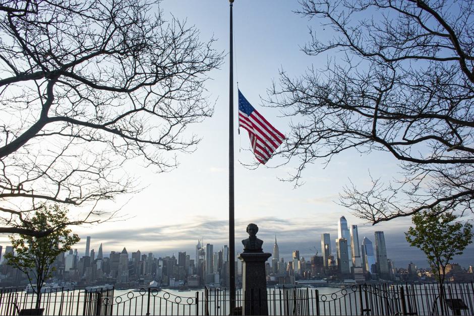 Las banderas ondean a media asta cuando sale el sol en Manhattan, visto desde Weehawken, Nueva Jersey. (Foto:&nbsp; Kena Betancur / Getty Images a través de AFP)&nbsp;