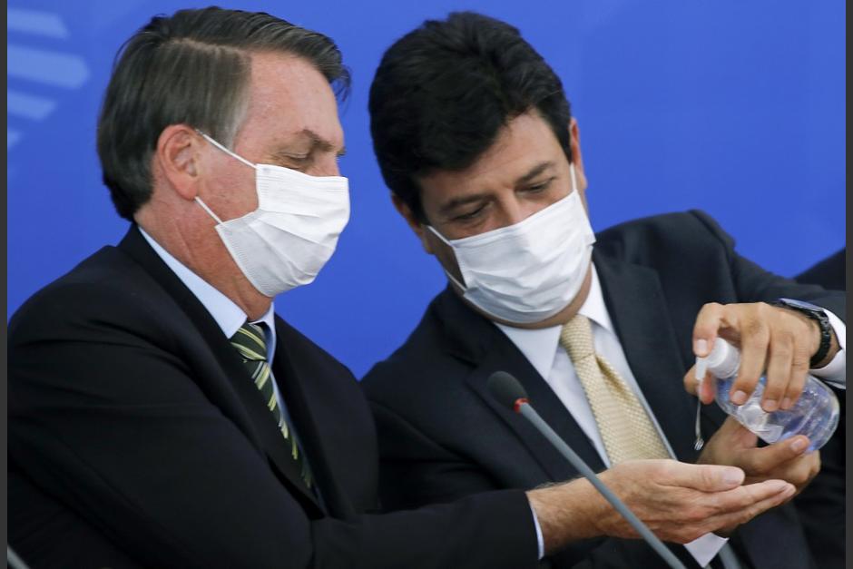 El presidente de Brasil recibe gel antibacterial de su antiguo ministro de Salud que ganó protagonismo por la crisis del coronavirus. (Foto: AFP)