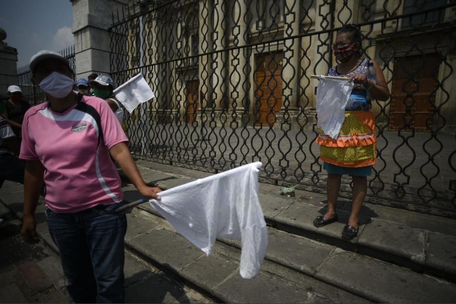 Decenas de personas han salido a puntos estratégicos para pedir ayuda utilizando banderas blancas. (Foto: Wilder López/Soy502)