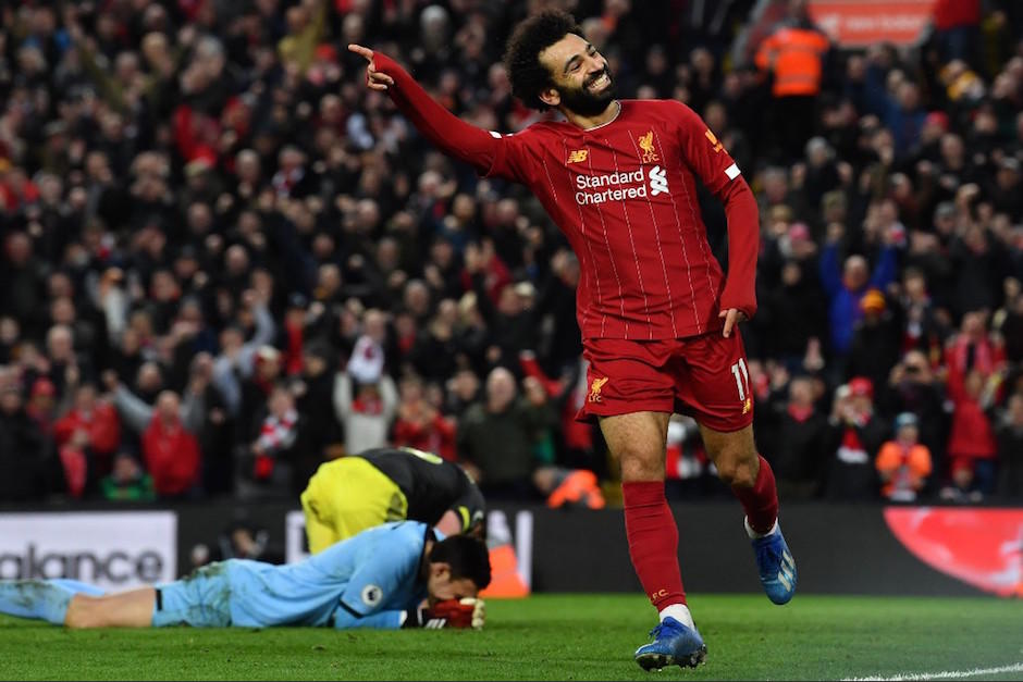 Mohamed Salah festeja el gol, mientras el portero rival y un defensa se lamentan al fondo. (Foto: AFP)
