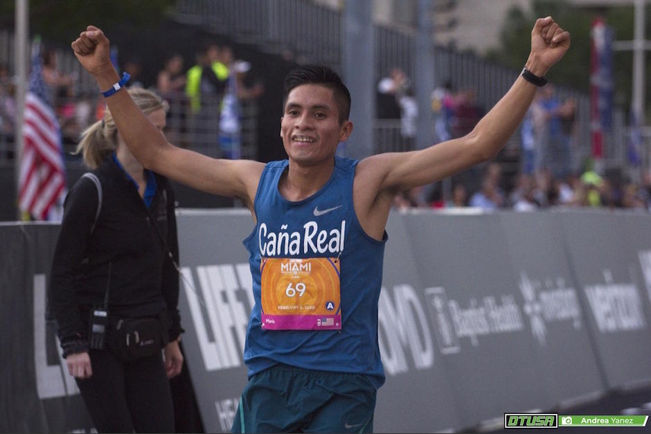 Mario Pacay alza los brazos en señal de triunfo al cruzar la meta del Medio Maratón de Miami. (Foto: Deporte Total USA)