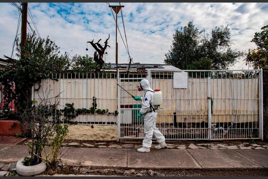Trabajador municipal limpia y desinfecta un vecindario vulnerable en Latinoamérica. (Foto: AFP)