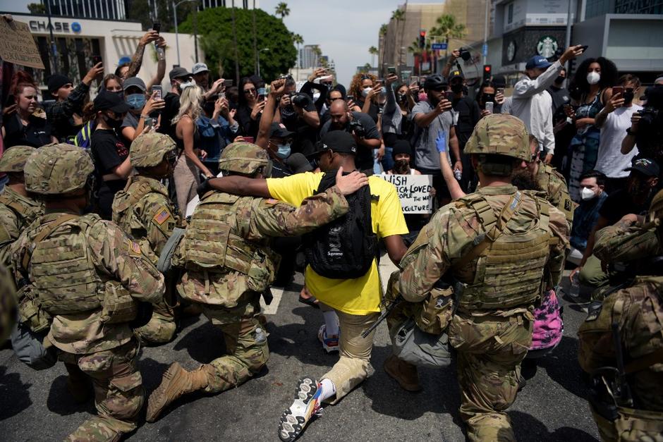 Los integrantes de la Guardia Nacional se solidarizaron con los manifestantes y se pusieron de rodillas como muestra de hermandad. (Foto: AFP)