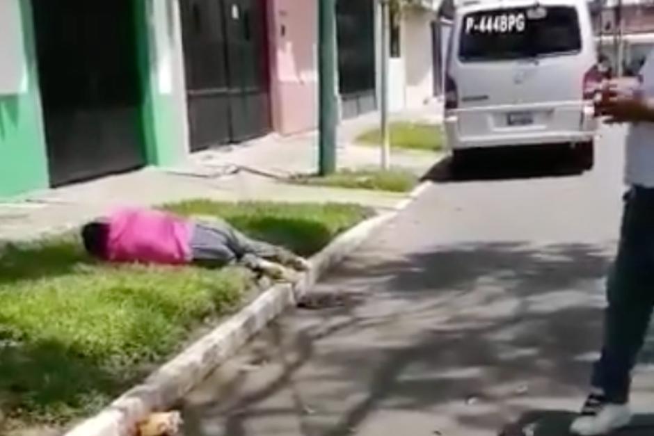 La mujer con síntomas de Covid-19 quedó sobre la grama en una calle de la colonia Jardines de la Asunción zona 5. (Foto: captura de pantalla)&nbsp;