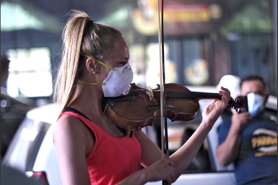 Una violinista deleitó a ciudadanos estadounidenses que esperaban el vuelo que los llevará de vuelta a casa en las afueras del aeropuerto La Aurora. (Foto: AFP)