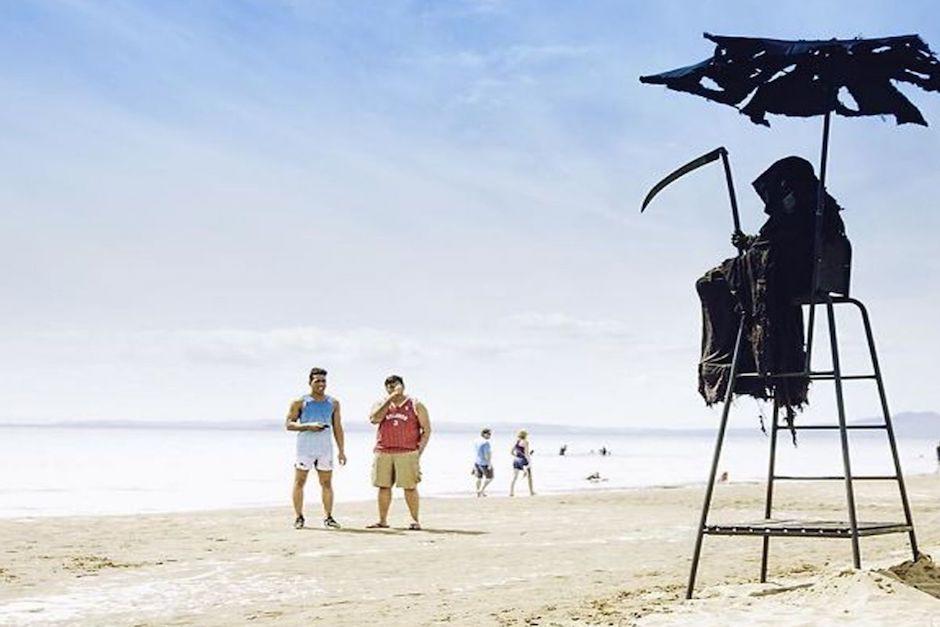 Un hombre disfrazado de muerte recorre las playas de Florida haciendo un llamado a las personas que no se quedan en&nbsp; su casa debido a la pandemia. (Foto: Daniel Uhlfelder)