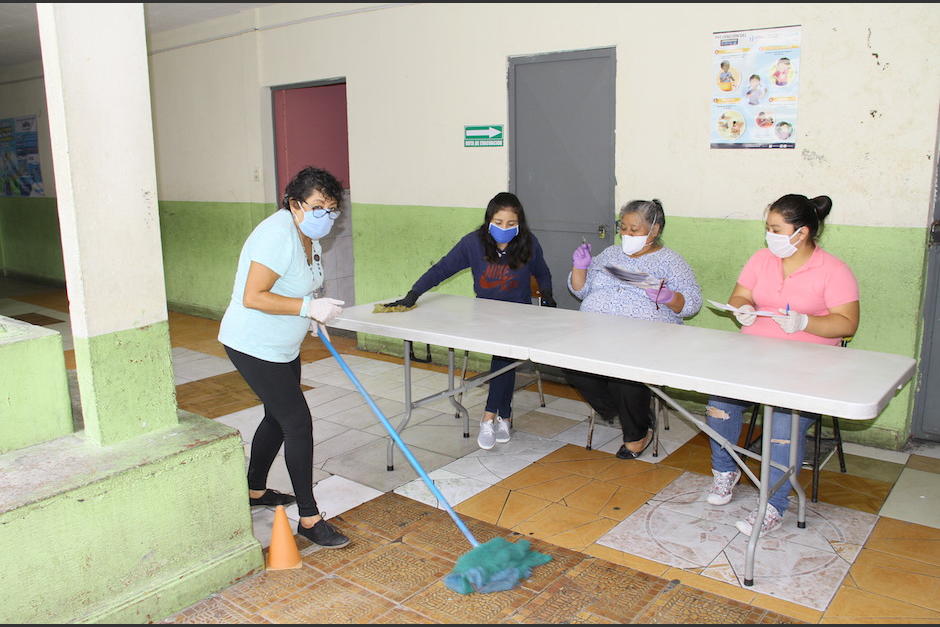 Maestras de la Escuela Oficial Urbana Mixta 155, ubicada en la colonia Lavarreda zona 18, entregaron guías de estudio a padres de familia. (Foto: Soy502)