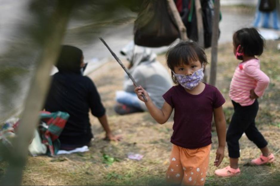 Niños juegan mientras sus padres agitan banderas blancas como señal que necesitan alimentos en un área de Villa Nueva. (Foto con fines ilustrativos/ Johan Ordóñez /AFP)&nbsp;