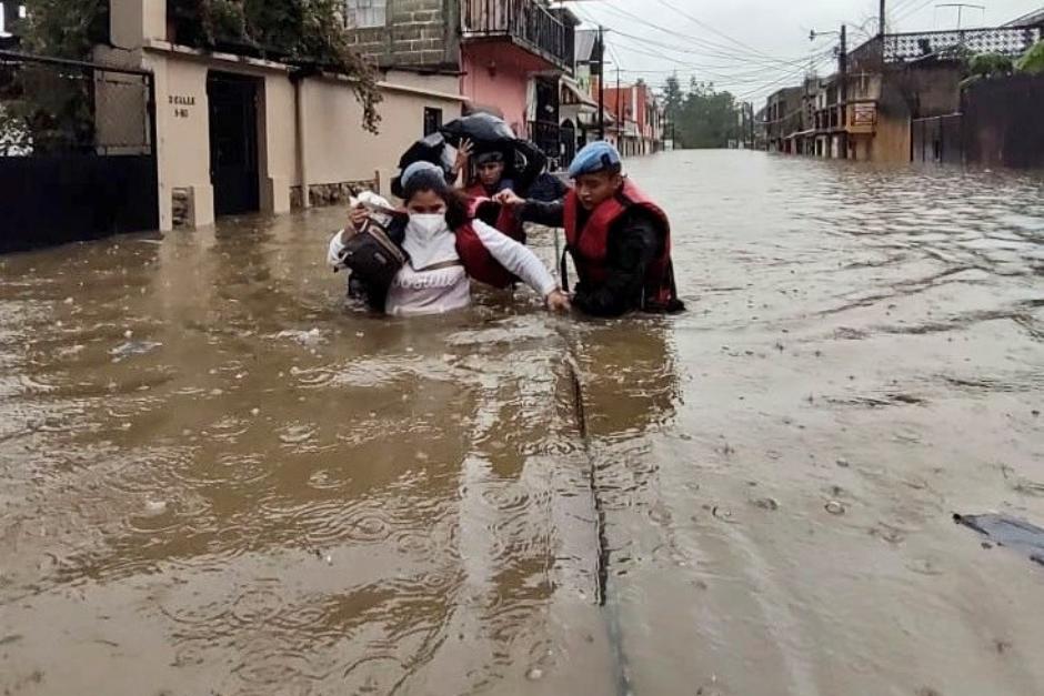 Una mujer es rescatada en una inundación. (Foto: Conred)&nbsp;