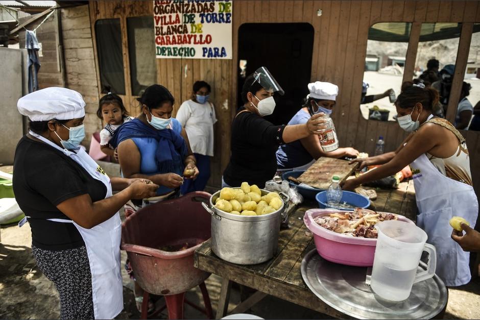 Varias mujeres voluntarias se organizan para preparar la comida destinada a familias de escasos recursos. (Foto: AFP)