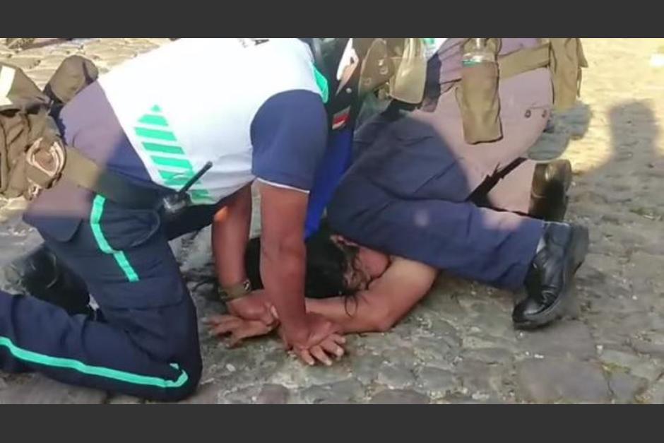 Policías Municipales de Antigua Guatemala, Sacatepéquez, toman por la fuerza a persona que caminaba desnudo por la Calle de las Ánimas. (Foto: Captura de Pantalla)