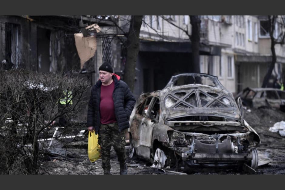 Un hombre camina junto a unos vehículos destruidos en un ataque con misiles sobre Kiev. (Foto: AFP)