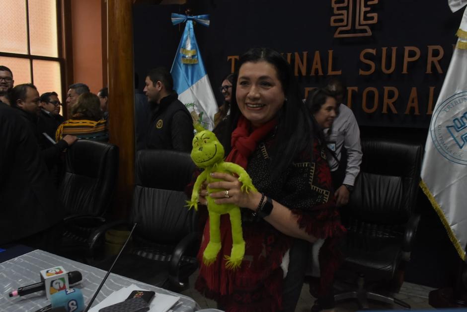 La presidenta del TSE, Blanca Alfaro, muestra el Grinch que le regalará a Rafael Curruchiche. (Foto: Wilder López/Soy502)