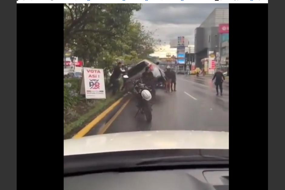 Un grupo de personas ayudó a mover un vehículo que volcó en la calzada Roosevelt y el video se volvió viral en redes sociales. (Foto: captura de pantalla)&nbsp;