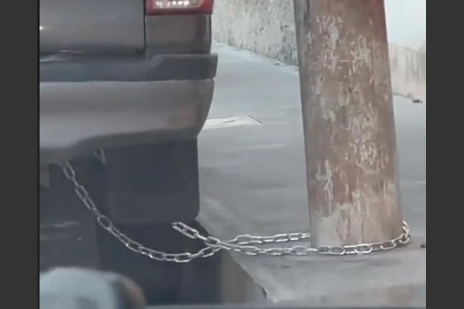 La peculiar forma en la que fue asegurado un vehículo estacionado, aparentemente en la zona 1 capitalina. (Foto: captura de video)
