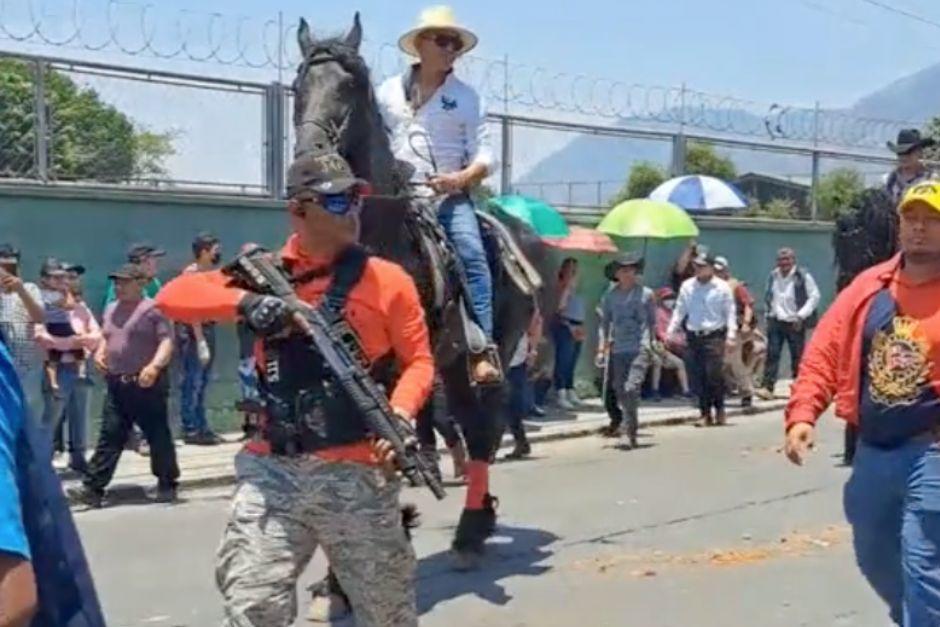 Un video que circula en redes sociales muestra a hombres armados con fusiles durante el desfile hípico realizado en Amatitlán, Guatemala. (Foto: captura de pantalla)