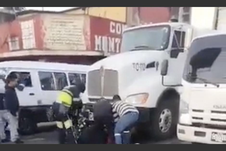 El motorista se salvó de ser atropellado y quedó atrapado en la parte frontal de un camión. (Foto: captura de video)