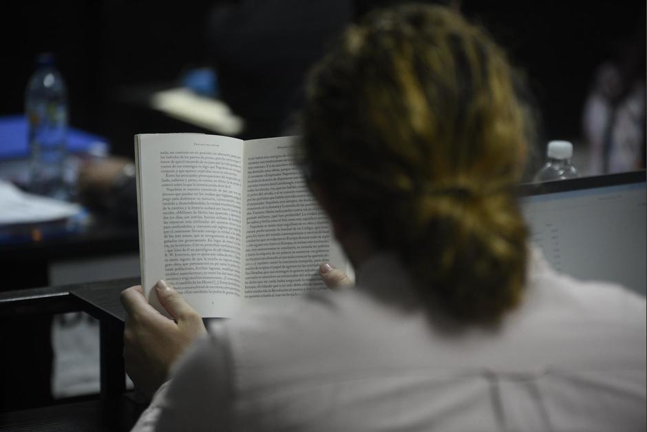 Javier de León, uno de los capturados por el caso Usac, se entretiene con un libro durante la audiencia. (Foto: Wilder López /Soy502)