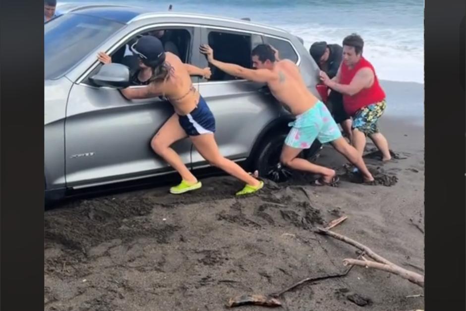 Un carro se quedó atorado a la orilla del mar en una playa guatemalteca y un grupo de personas se hizo viral en redes sociales tras intentar sacarlo del precipicio. (Foto: captura de pantalla)&nbsp;