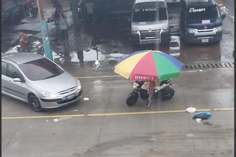 El motorista se cubrió de la lluvia de una peculiar manera, pero casi termina arrollado. (Foto: captura de video)