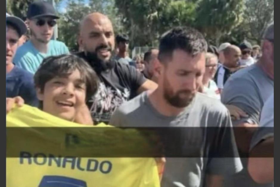 Leo Messi junto a un niño que muestra la camisola de Cristiano Ronaldo. (Foto: OOCF)