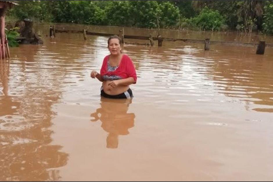 Una de las damnificadas trata de resguardarse luego que su vivienda quedara inundada. (Foto: Conred)