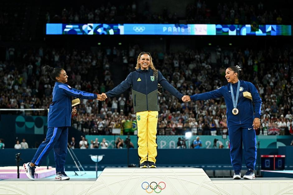 Las conmovedoras reverencias de las gimnastas en el podio ante el oro de la brasileña, Rebeca Andrade. (Foto: AFP)