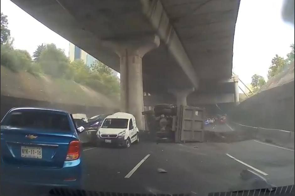 El conductor logró pasarse al carril central justo cuando un camión volcó y se llevó varios carros por delante. (Captura Video)