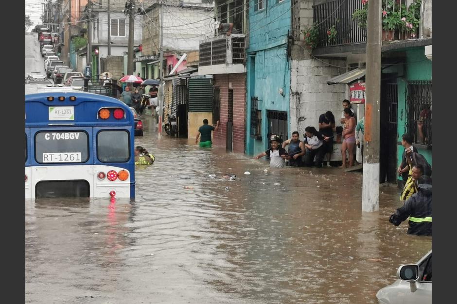 Bomberos Voluntarios cumplen su misión en rescatar a pasajeros del bus que quedaron varados en el agua sucia provocados por las fuertes lluvias. (Foto: La Hora)&nbsp;