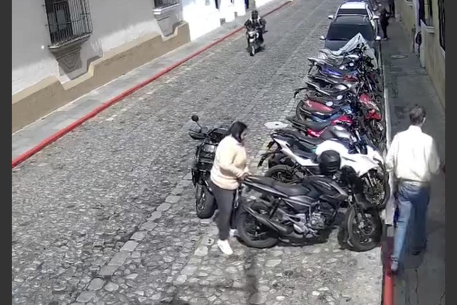 Una cámara de seguridad captó el momento en que una mujer movió una moto a franja roja para poder estacionar la de ella en Antigua Guatemala. (Foto: captura de pantalla)&nbsp;