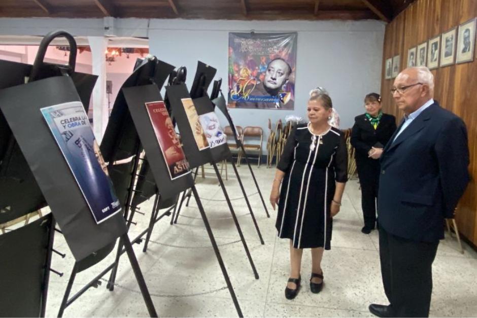 Ana Julieta Cárdenas, presidenta de la APG, muestra a Miguel Ángel Asturias Amado los afiches que concursan en ocasión del 125 aniversario del nacimiento de su padre. (Foto: Jéssica Osorio/Soy502)