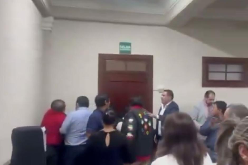 En la imagen se puede observar a Aldo Dávila (rojo) su hermano Kenny (sudadero negro) junto a otros trabajadores del Congreso mientras ocurría el desacuerdo en la sesión extraordinaria. (Captura de pantalla/Karina Paz)