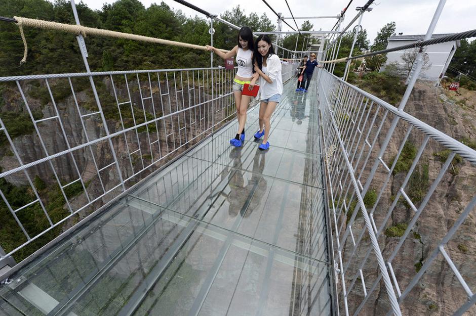 Dos mujeres caminan sobre el puente que es seguro, pero ver hacia abajo hace que sientan la sensación de estar en peligro. (Foto: China Daily)