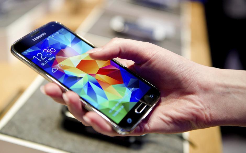 Una mujer sostiene en su mano un teléfono inteligente Samsung Galaxy S5. (Foto: EFE/Archivo)