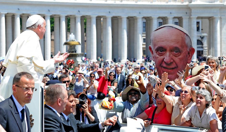 El papa Francisco saluda a un grupo de fieles que sujetan una pancarta con su rostro, a su llegada a la audiencia general de los miércoles, en la Plaza de San Pedro, en la Ciudad del Vaticano ayer. (Foto: EFE)