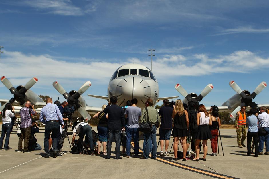 Reporteros permanecen en la pista previo al despegue de un P-3 Orion de la fuerza de defensa japonesa hoy, 24 de marzo de 2014, desde la base aérea de Pearce, cerca de Perth, para unirse a las labores de búsqueda de los restos del avión MH370 de la compañía Malaysia Airlines desaparecido el pasado día 8 de Marzo. (Foto: EFE)