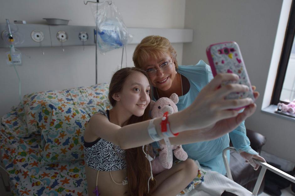 &nbsp;Michelle Bachelet, mientras se toma una fotografía con Valentina Maureira, la joven de 14 años que padece fibrosis quística y que pidió en un vídeo a la mandataria autorización para morir. (Foto: EFE)