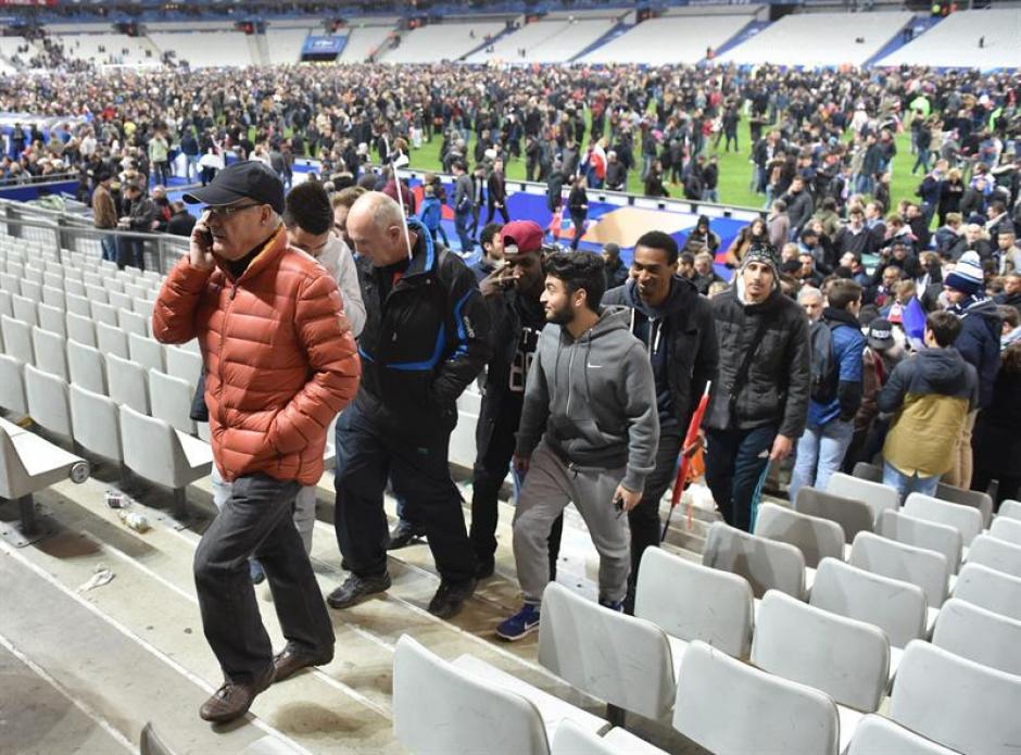 Tras la explosión, la gente saltó a la cancha para estar a salvo. El juego quedó suspendido y las personas tuvieron que abandonar el recinto deportivo francés. (Foto: EFE)