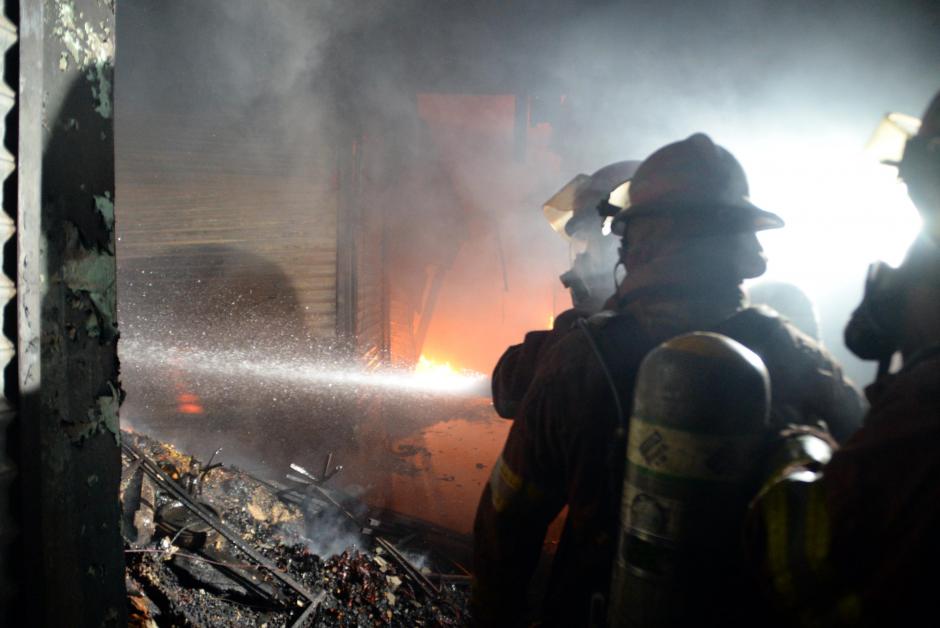 Bomberos luchan por sofocar el fuego en el interior del Mercado La Terminal. (Foto: Esteban Biba/ Soy502)