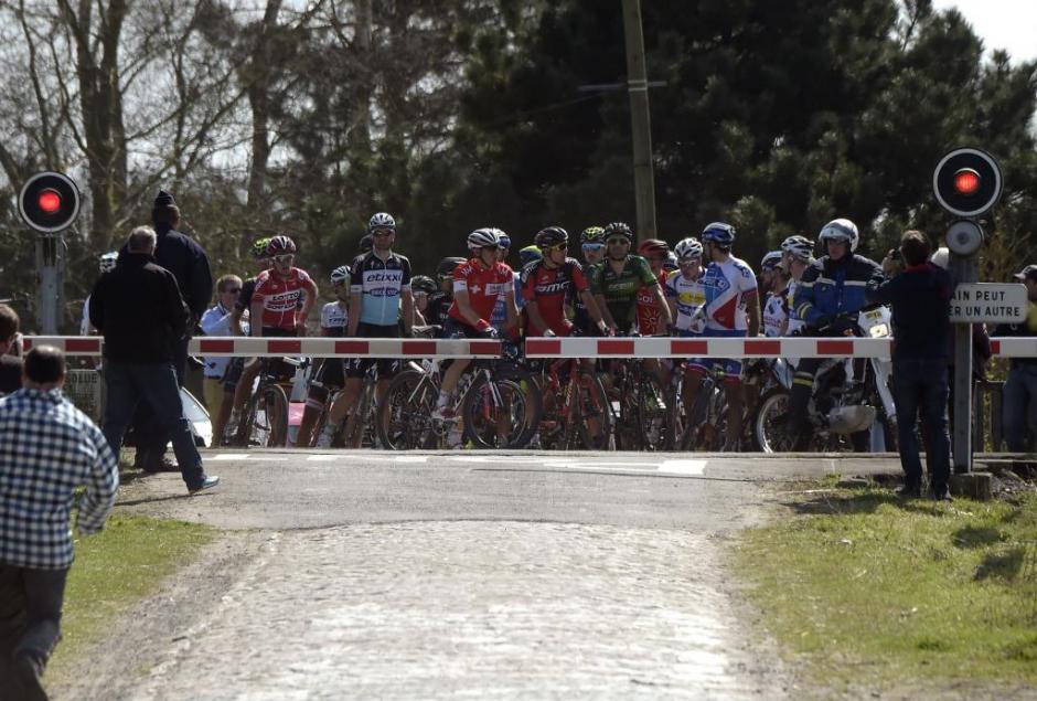 La curiosa imagen del día en la Vuelta&nbsp;París-Roubaix, en Francia, los ciclistas se tuvieron que detener para que pasara el tren. (Foto: Tomada de Marca)