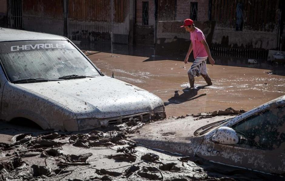 Las personas caminan aún por las calles inundadas en la localidad de Paipote en Chile. &nbsp;(Foto: EFE)&nbsp;